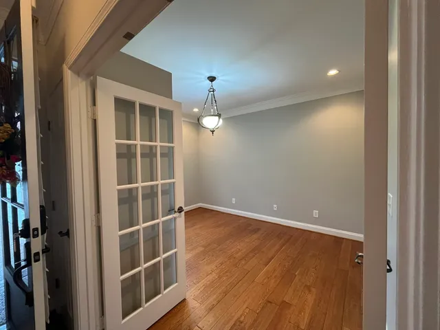 en empty room with wooden floor and windows