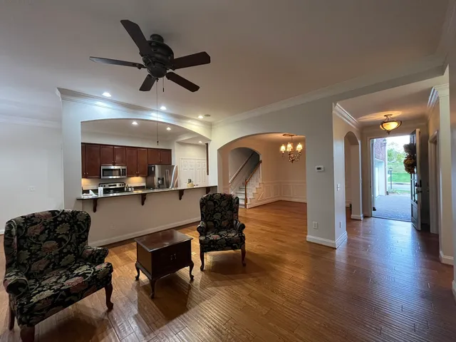 a living room with furniture and a wooden floor