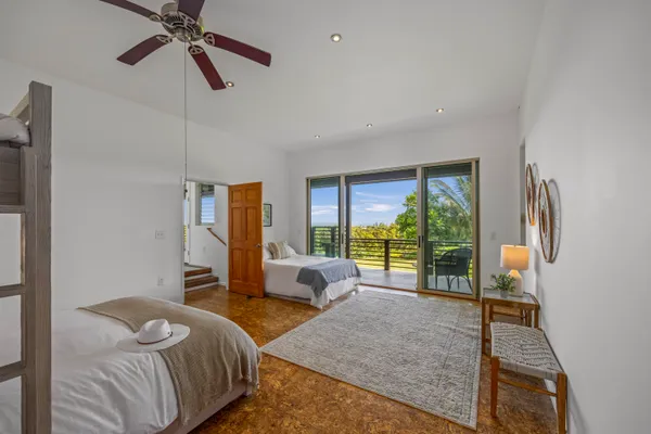 a bedroom with a bed and large windows