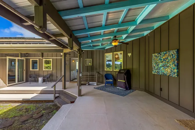 a view of a porch with chairs and floor to ceiling window