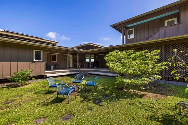 a view of a house with backyard sitting area and swimming pool