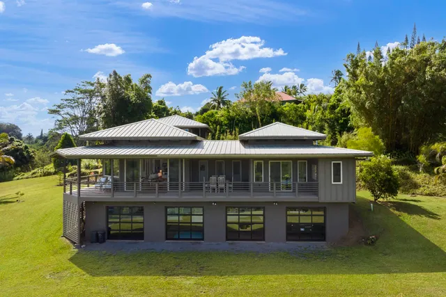 a front view of a house with yard swimming pool and outdoor seating
