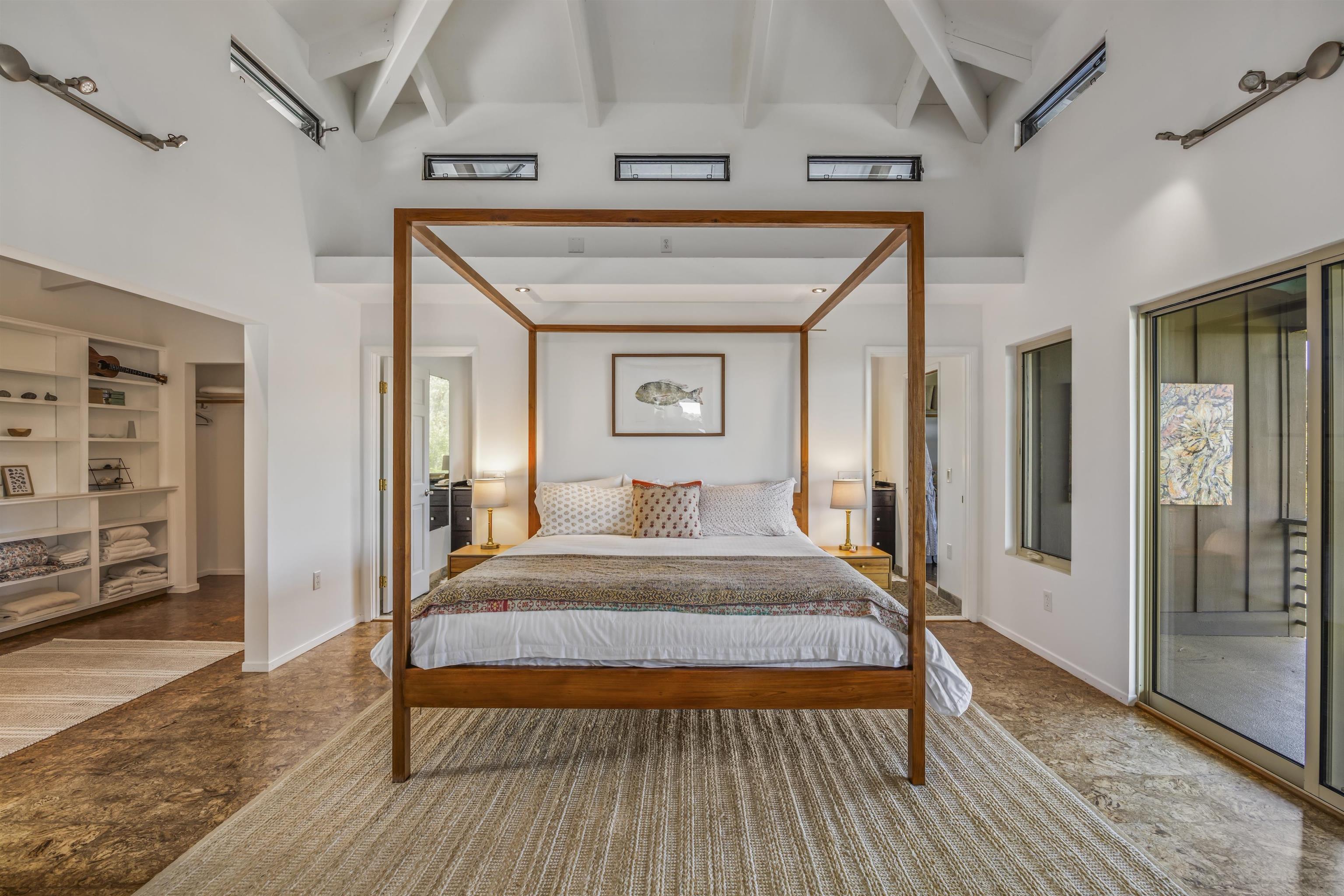 41 Leleaka Place, Unit A Haiku, HI 96708 - Photo 10 of 40 a bedroom with a bed and a large mirror with a wooden floor