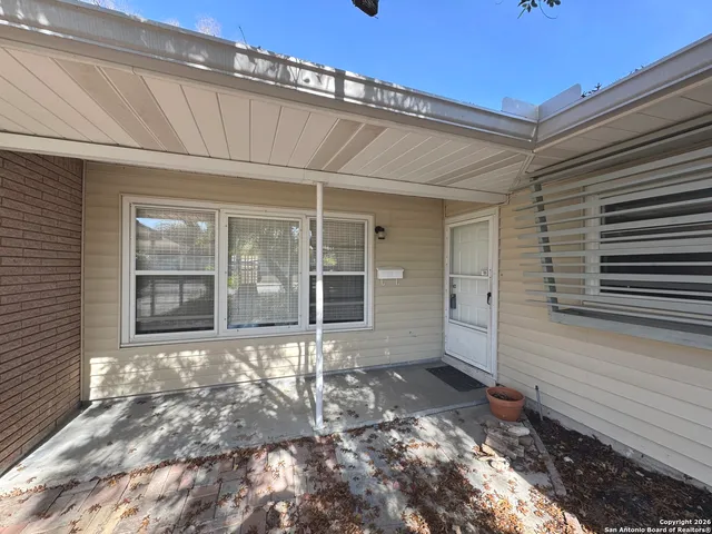 a view of a house with a small yard and floor to ceiling window and wooden floor