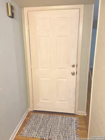 a view of a room with wooden floor and white door
