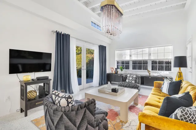 a living room with furniture a flat screen tv and a large window