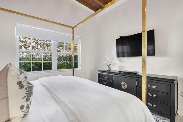 a bedroom with a large bed and a flat screen tv