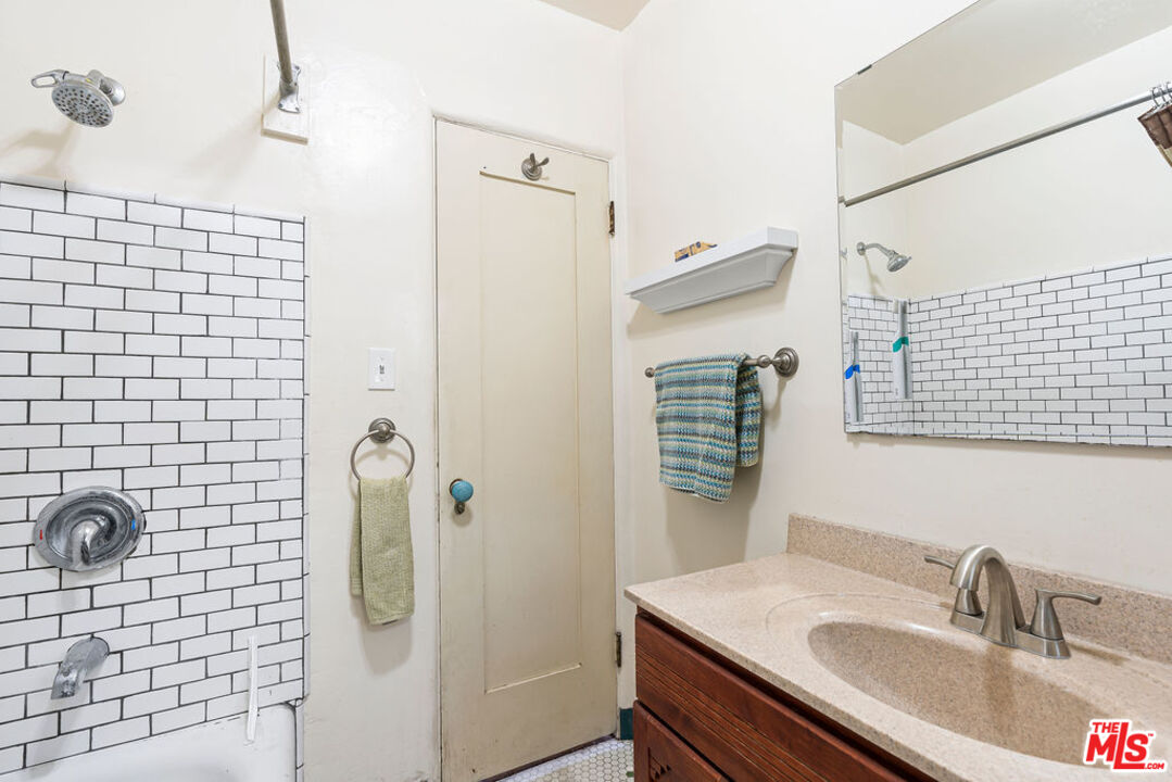 2403 Hyperion Avenue Los Angeles, CA 90027 - Photo 19 of 53 a bathroom with a sink vanity granite shower and a mirror