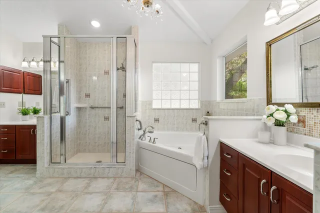 a bathroom with a tub sink shower and mirror
