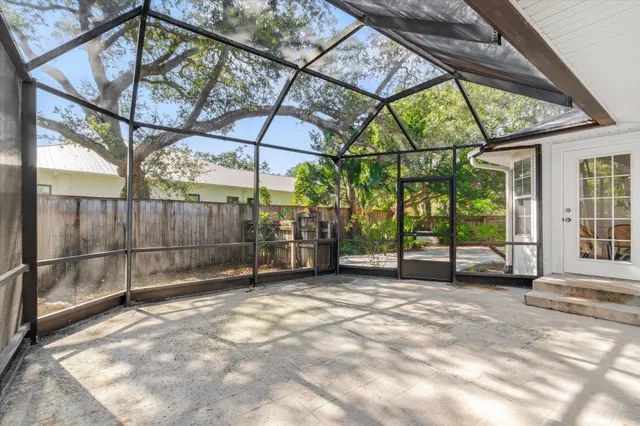 a view of a yard with potted plants and large trees