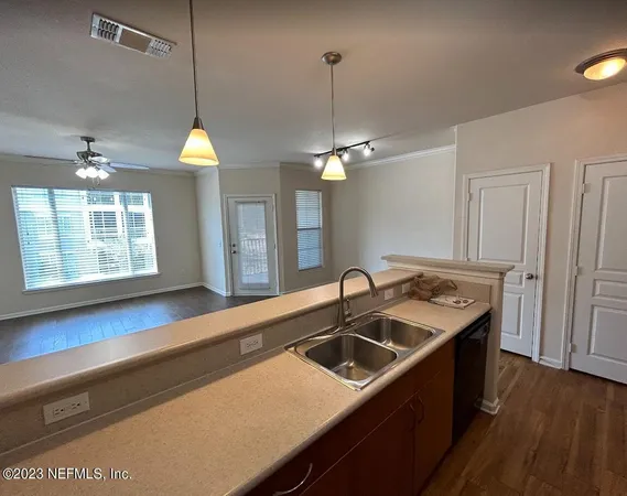 a kitchen with a sink cabinets and wooden floor