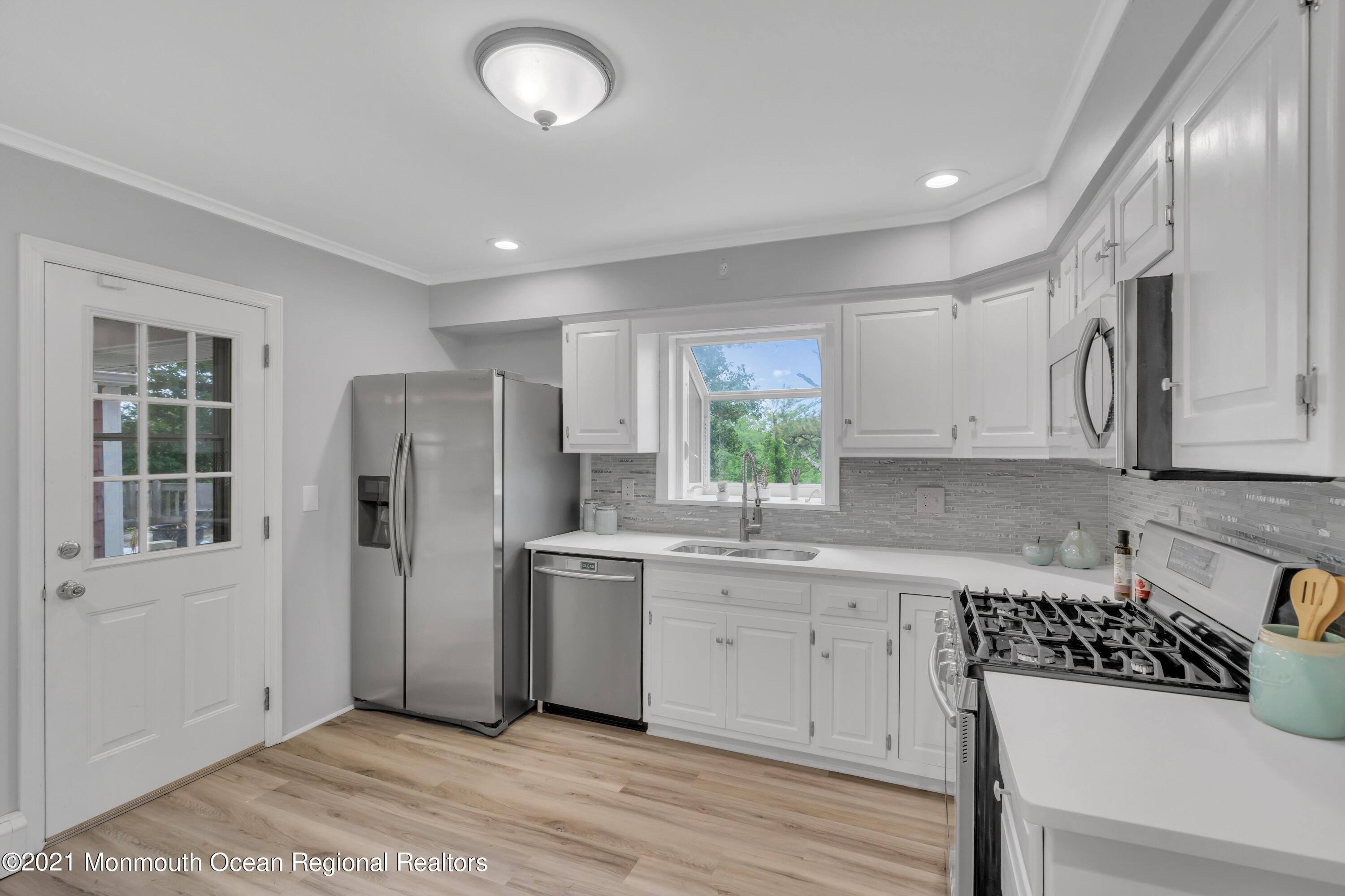 1675 Forge Pond Road Brick, NJ 08724 - Photo 17 of 69 a kitchen with a refrigerator a sink dishwasher a stove and white cabinets with wooden floor
