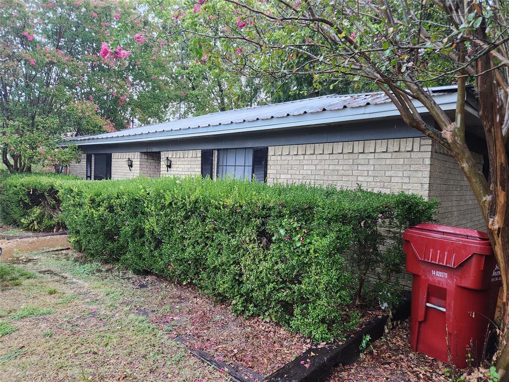209 East 2nd Street Quinlan, TX 75474 - Photo 1 of 13 a backyard of a house with outdoor seating and trees
