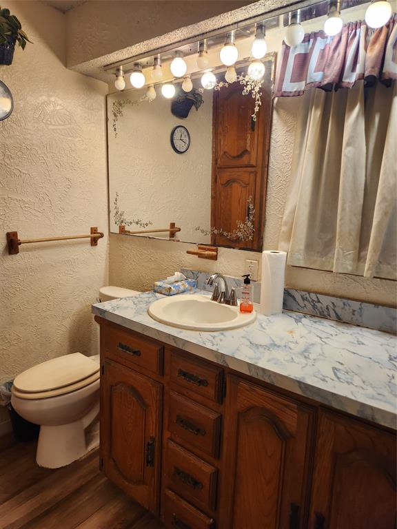209 East 2nd Street Quinlan, TX 75474 - Photo 13 of 13 a bathroom with a granite countertop sink toilet and shower