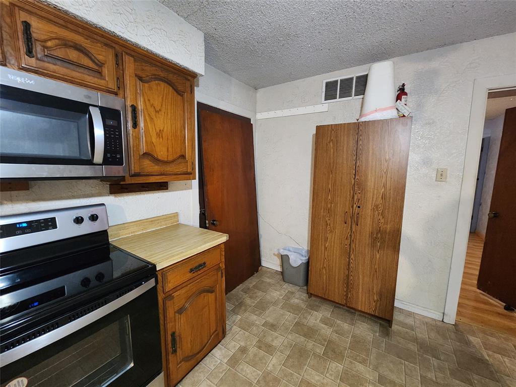 209 East 2nd Street Quinlan, TX 75474 - Photo 3 of 13 a kitchen with a stove and a microwave