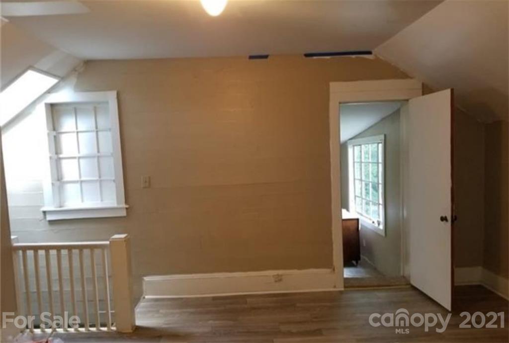 5226 Tuckaseegee Road Charlotte, NC 28208 - Photo 16 of 18 an empty room with wooden floor and windows