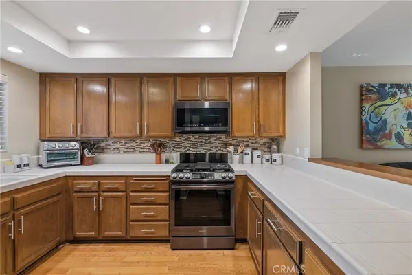 a kitchen with stainless steel appliances granite countertop a refrigerator and a sink