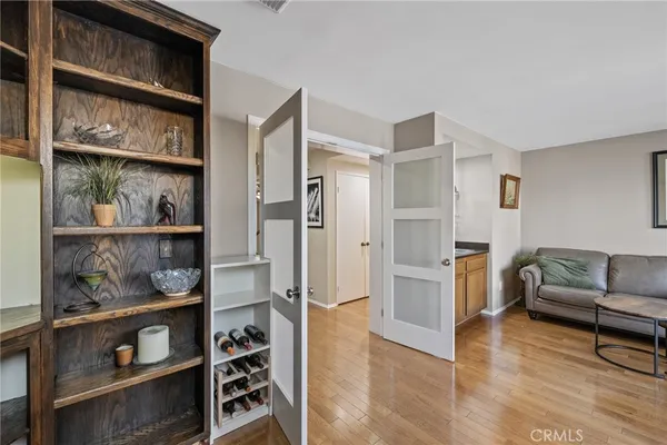 a bedroom with a bed wooden floor and flat screen tv