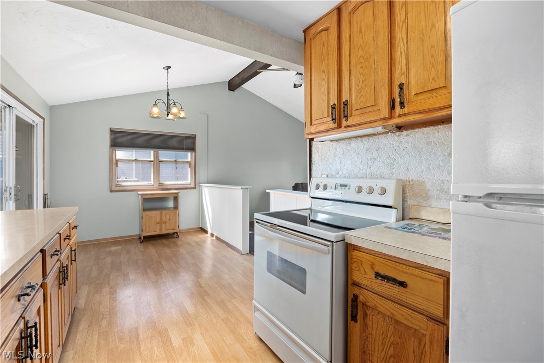 5697 Jaycox Road North Ridgeville, OH 44039 - Photo 7 of 28 Kitchen with vaulted ceiling with beams, white appliances, light hardwood / wood-style flooring,