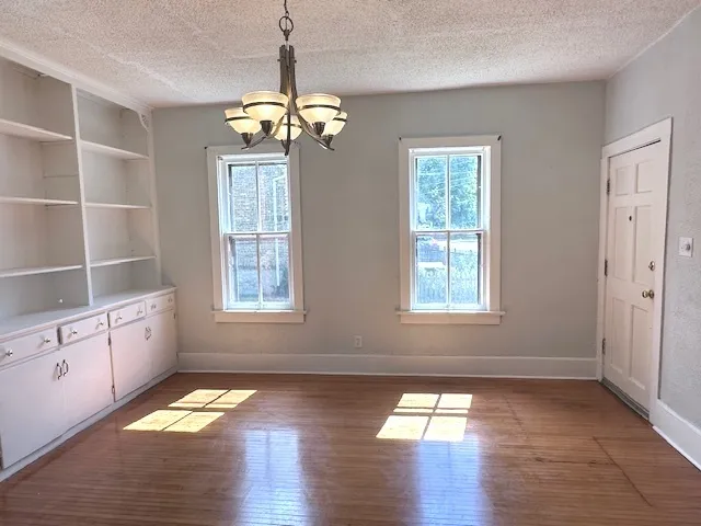 an empty room with wooden floor and a ceiling fan