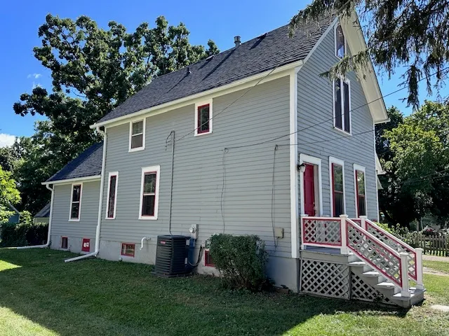 a view of a house with potted plants and a yard