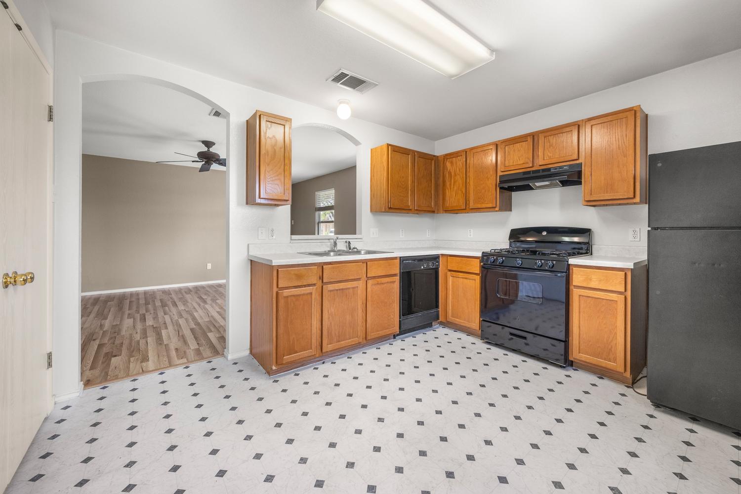 359 Spring Branch Loop Kyle, TX 78640 - Photo 8 of 17 a kitchen with a sink a stove a refrigerator and black cabinets