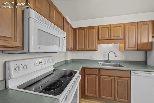 a kitchen with granite countertop a sink a stove and cabinets