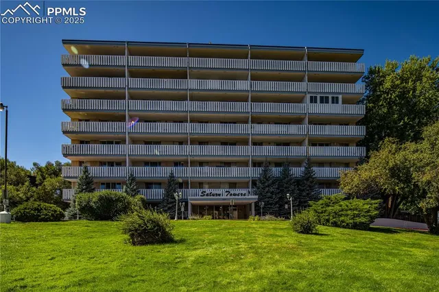a living room with furniture a chandelier and a flat screen tv