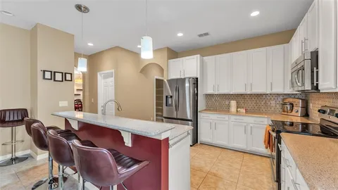a kitchen with a stove a refrigerator and a dining table