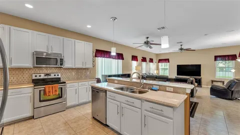 a living room with furniture a flat screen tv and a large window