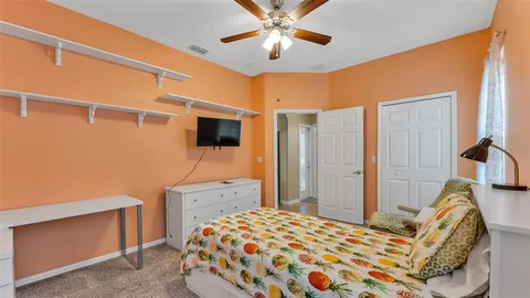 a spacious bedroom with a bed and a chandelier