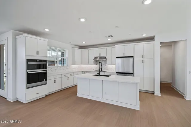 a kitchen with stainless steel appliances kitchen island a refrigerator and a stove top oven