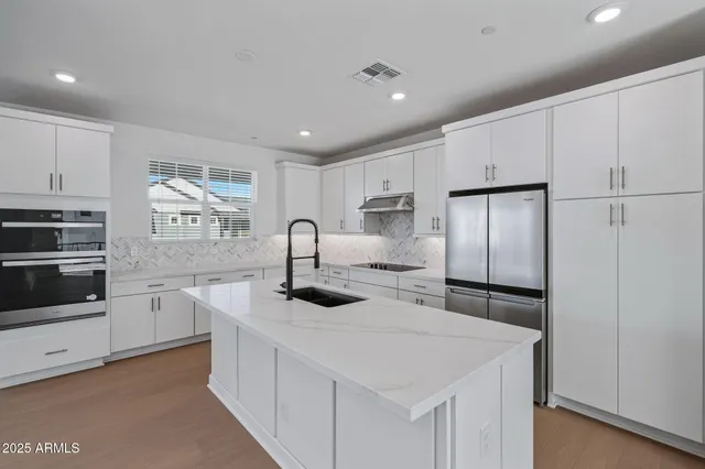 a kitchen with stainless steel appliances granite countertop a sink stove and cabinets