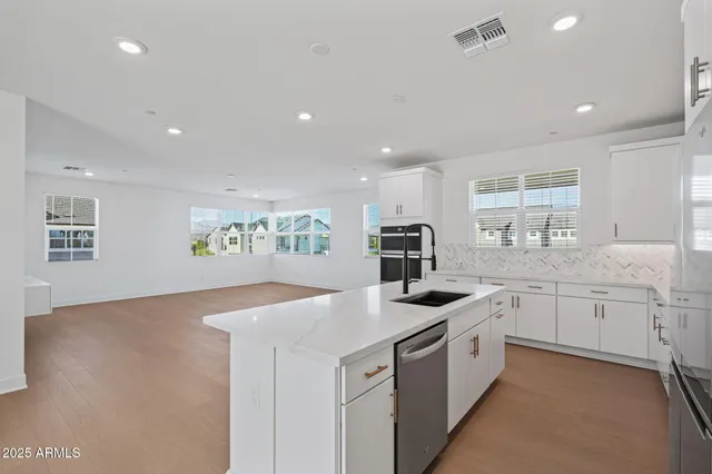 a view of a kitchen with refrigerator and white cabinets