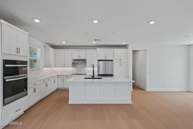 a kitchen with stainless steel appliances a white stove top oven cabinets and a refrigerator