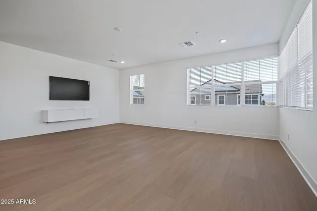 a view of empty room with kitchen and window