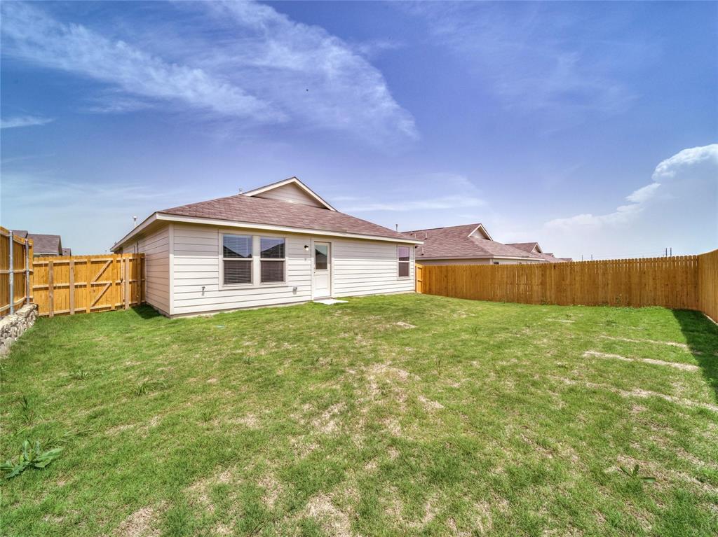 357 Sun Bluff Road Fort Worth, TX 76052 - Photo 21 of 35 Spacious backyard featuring a full wood privacy fence, a gabled roofline, and a rear exterior door