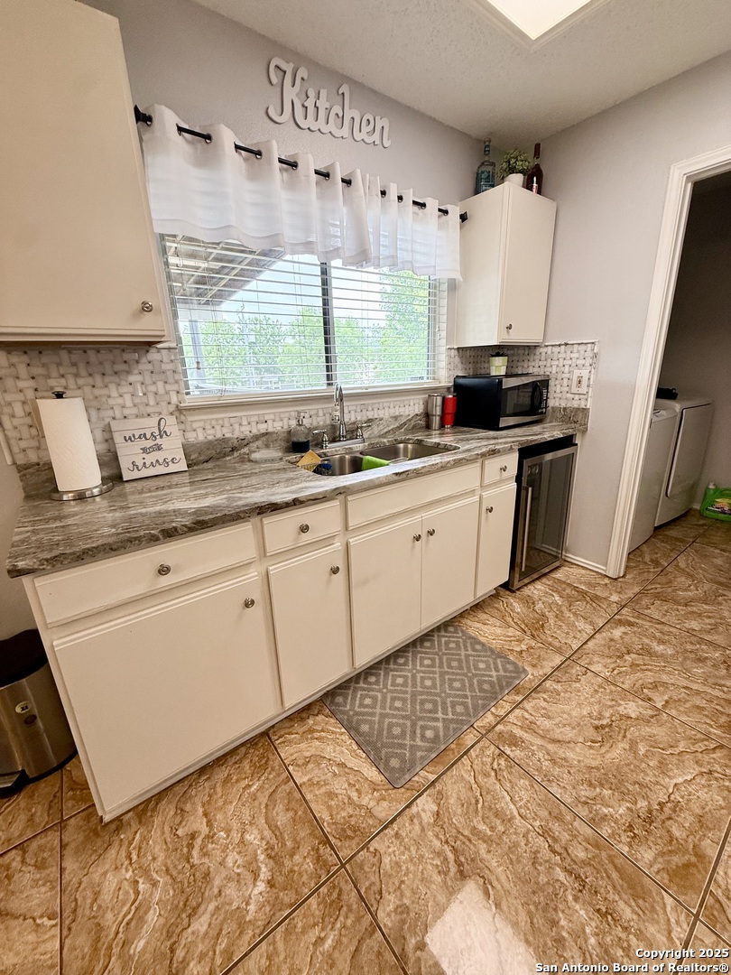 6719 Raintree Path San Antonio, TX 78233 - Photo 11 of 24 a kitchen with granite countertop white cabinets and white appliances