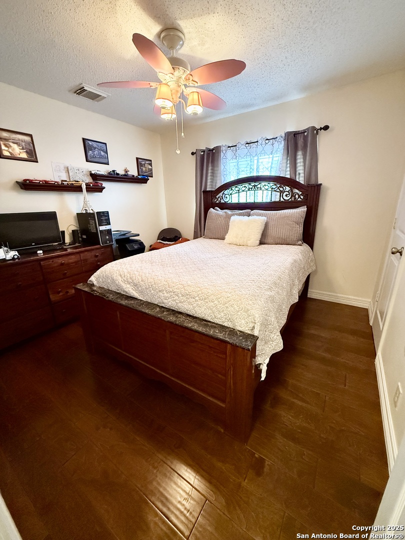 6719 Raintree Path San Antonio, TX 78233 - Photo 15 of 24 a bed sitting in a bedroom and view of kitchen