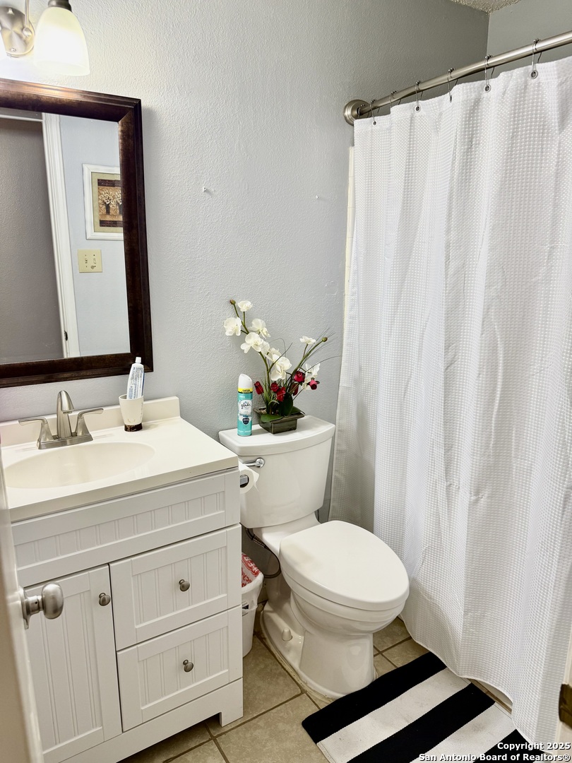 6719 Raintree Path San Antonio, TX 78233 - Photo 16 of 24 a bathroom with a sink a mirror and a toilet