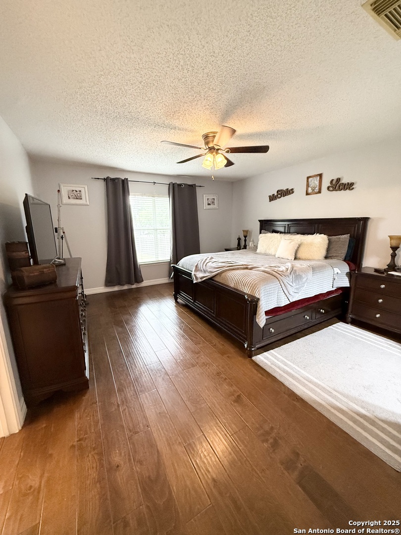 6719 Raintree Path San Antonio, TX 78233 - Photo 18 of 24 a bedroom with two beds and a chandelier