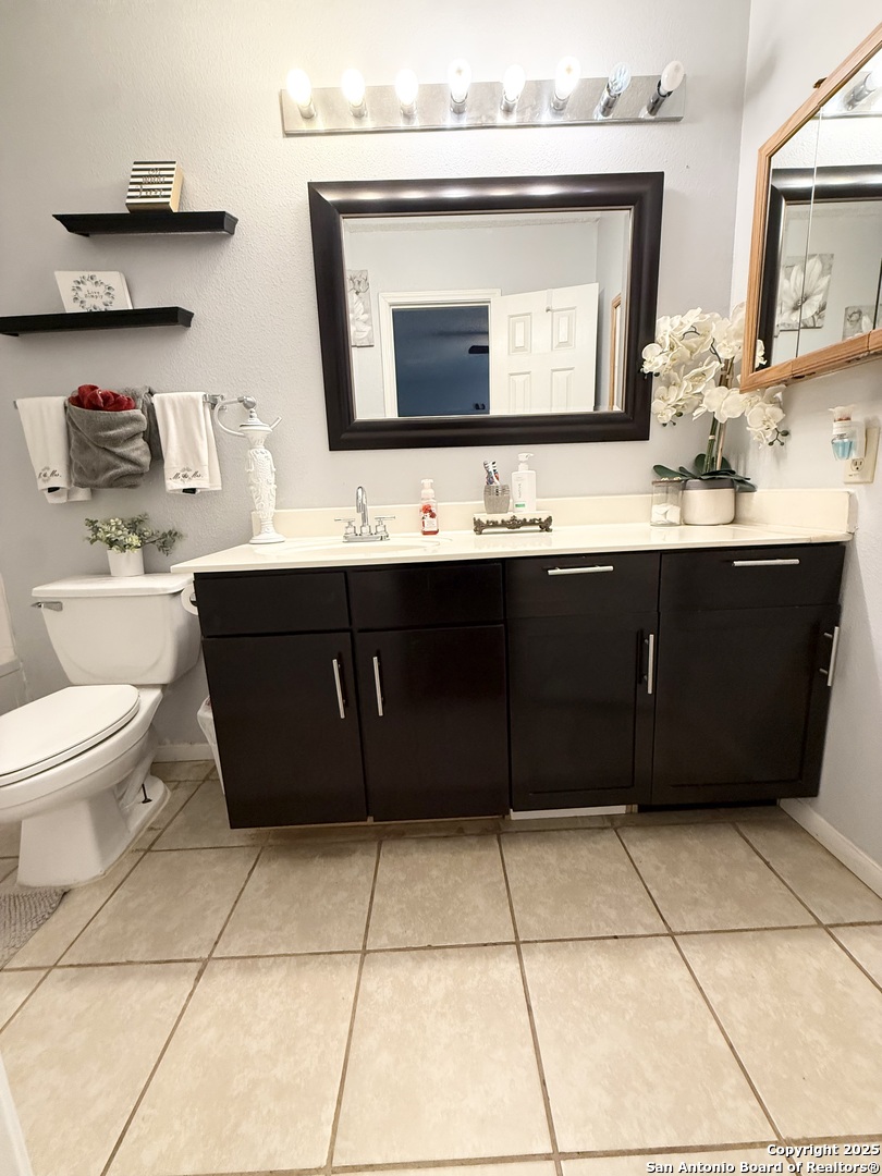 6719 Raintree Path San Antonio, TX 78233 - Photo 21 of 24 a bathroom with a sink a toilet and mirror