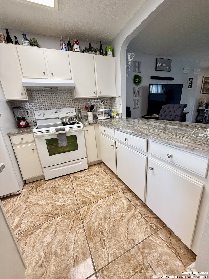 6719 Raintree Path San Antonio, TX 78233 - Photo 10 of 24 a kitchen with a stove top oven and white cabinets