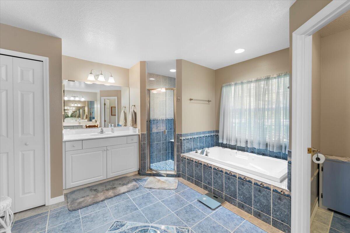 3455 Carter Road Mims, FL 32754 - Photo 13 of 38 a bathroom with a tub a sink a mirror and a shower