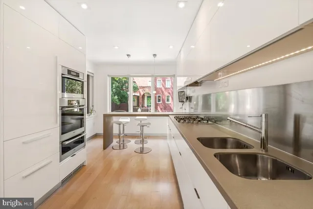 a kitchen with a sink and wooden floor
