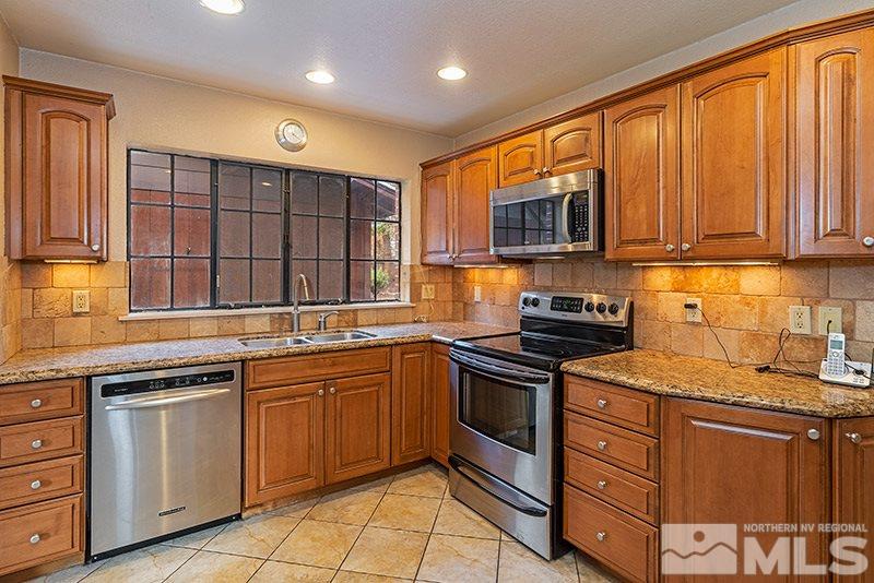 844 Whitaker Drive Reno, NV 89503 - Photo 21 of 34 a kitchen with stainless steel appliances granite countertop wooden cabinets sink and a granite counter top