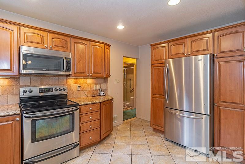 844 Whitaker Drive Reno, NV 89503 - Photo 22 of 34 a kitchen with stainless steel appliances granite countertop a refrigerator stove and microwave