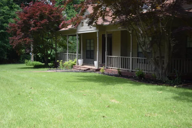 a view of a chair and table in backyard of the house