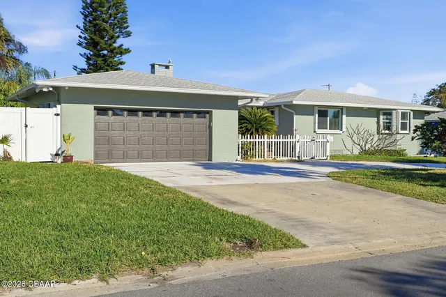 a front view of a house with a garden and yard