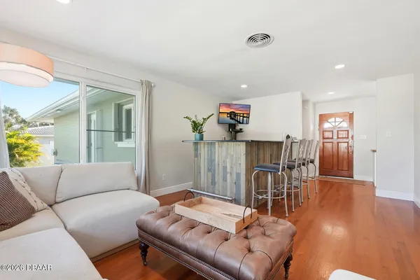 a living room with furniture and a wooden floor